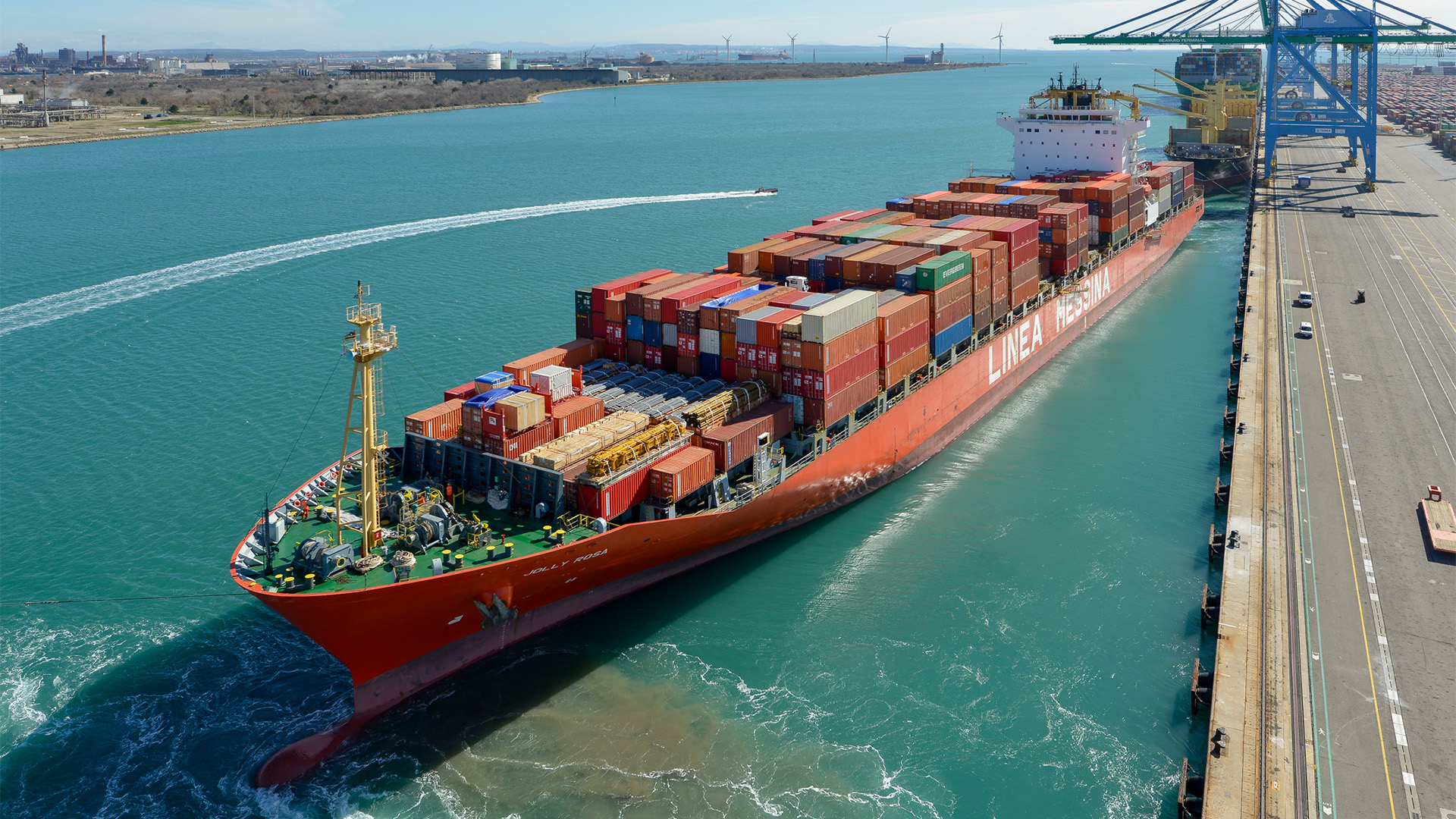The ship 'Jolly Rosa', loaded with containers, leaving the port.