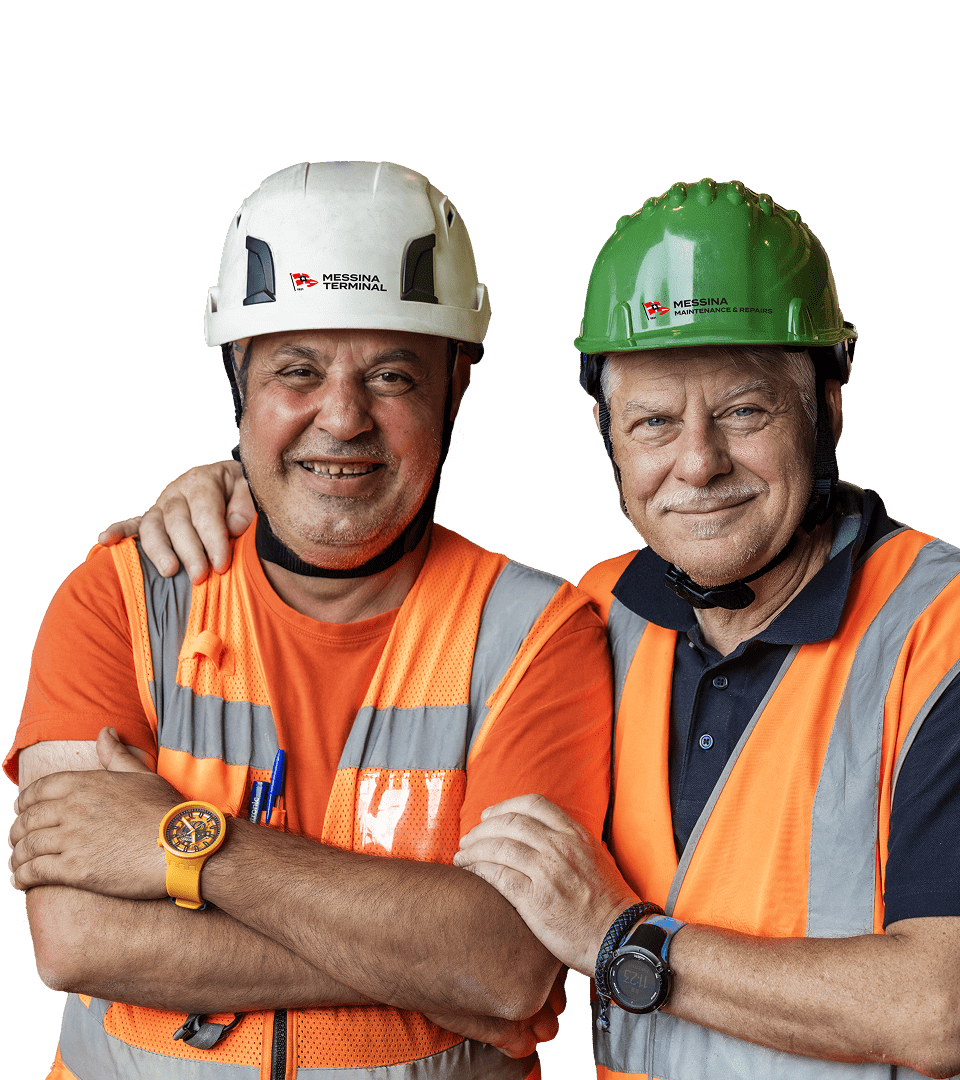 Portrait of two mature men posing smiling with crossed arms and construction helmets. The first wears a white helmet and is a worker from Messina Terminal, the second wears a green helmet and is the manager of the Messina Maintenance & Repair Business Unit. They both wear high-visibility orange vests and support each other